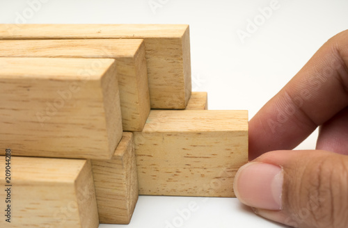 wooden block stack close up with hand on white background