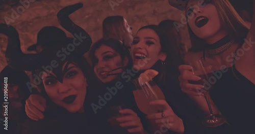 Young women drinking and having fun at nightclub Halloween party