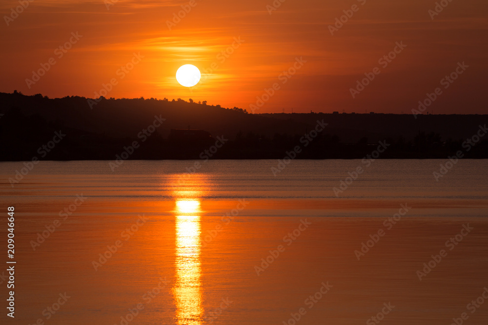 orange sunset, great sun reflected in the water, coastline, concept nature and summer