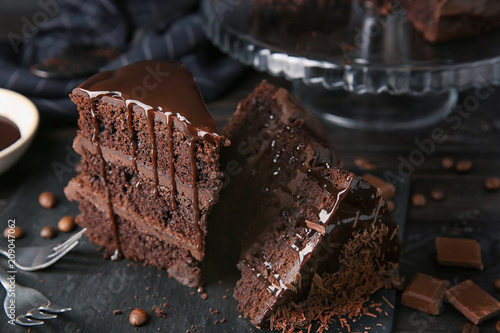 Fotografija Pieces of tasty chocolate cake on table