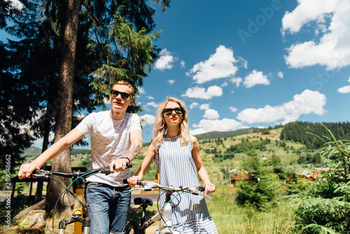 young couple in love ride on bicycles in the mountains