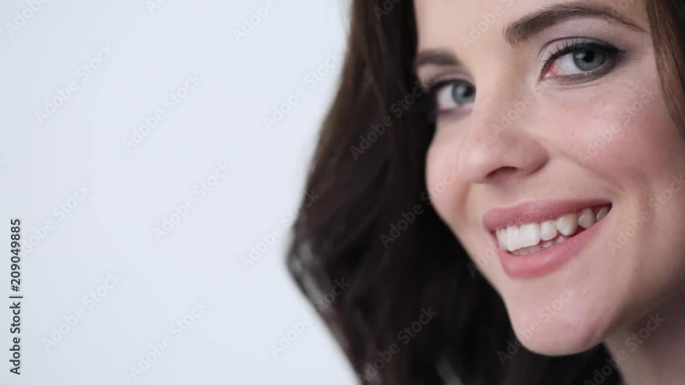 Beauty woman with smiling in studio. Girl face closeup slow motion. Beauty woman with smiling in studio. Girl face closeup slow motion.