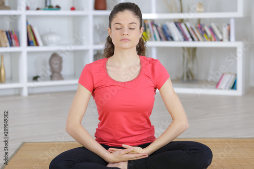 content brunette sitting in lotus pose at home