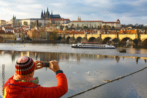 Canvas Print Tourist photographing Prague with Charles Bridge and Hradcany