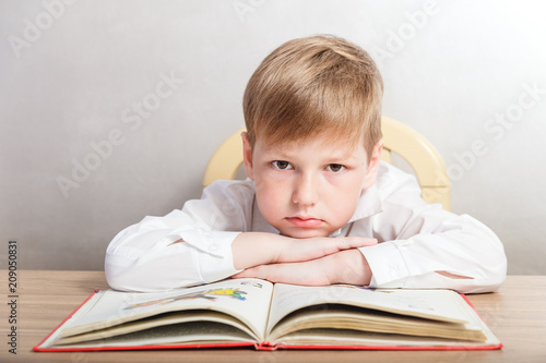 boy in a white shirt sitting at his Desk