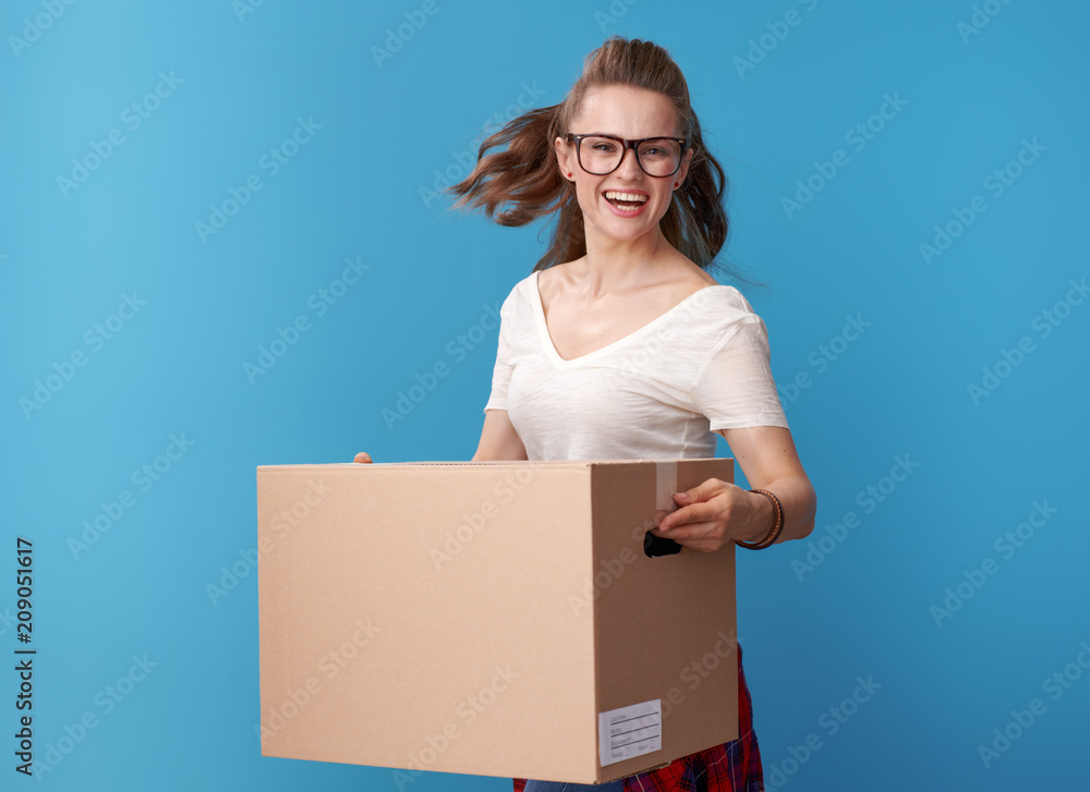 cheerful woman in white shirt with cardboard box on blue cheerful woman in white shirt with cardboard box on blue