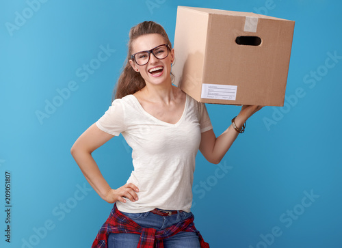 smiling young woman in white shirt with cardboard box on blue