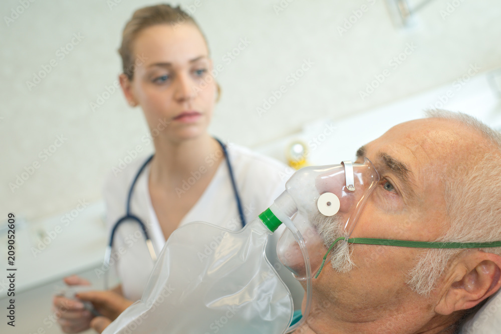 close-up of senior man using oxygen mask in clinic close-up of senior man using oxygen mask in clinic