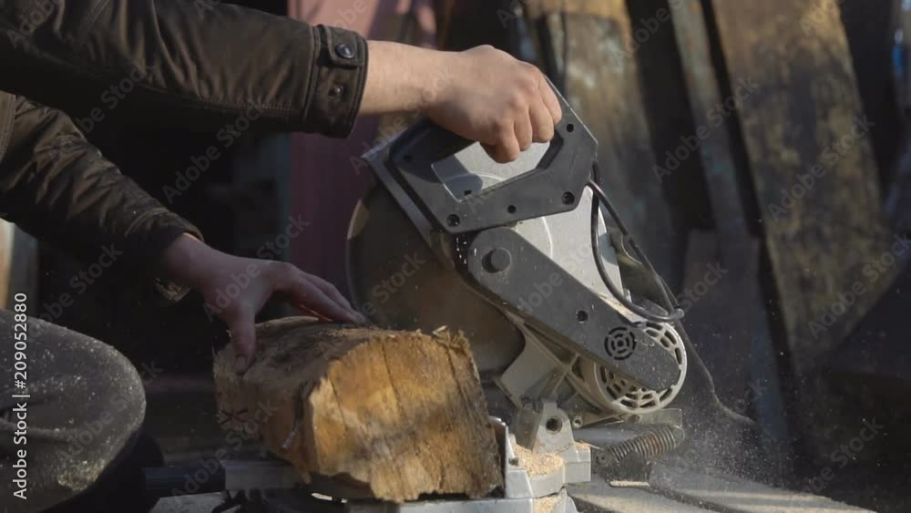 Man saws a wooden log with a large saw, slow motion Man saws a wooden log with a large saw, slow motion