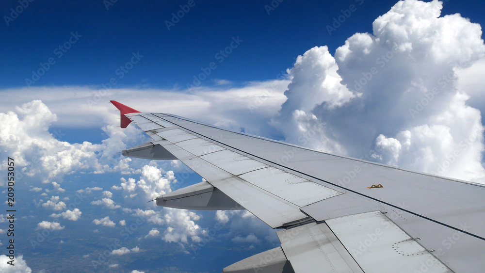 white clouds and blue sky as seen through window of an aircraft. travel and vacation concept white clouds and blue sky as seen through window of an aircraft. travel and vacation concept