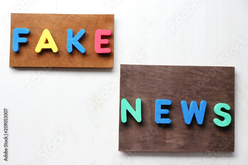 Words FAKE NEWS made of letters on wooden background