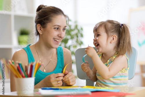 Mom helping her child to work colored paper