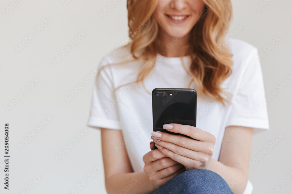 Cropped image of young redhead woman using mobile phone. Cropped image of young redhead woman using mobile phone.