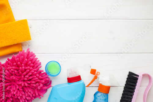 Set of cleaning products on the wooden background. Plastic bottles  detergent and brushes. Service concept. Top view. Close up.