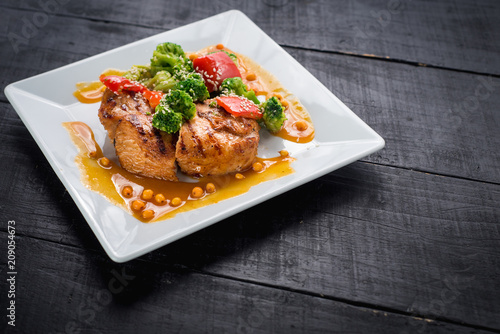 Tasty fried chicken meat with vegetables and lentils sauce on wooden background