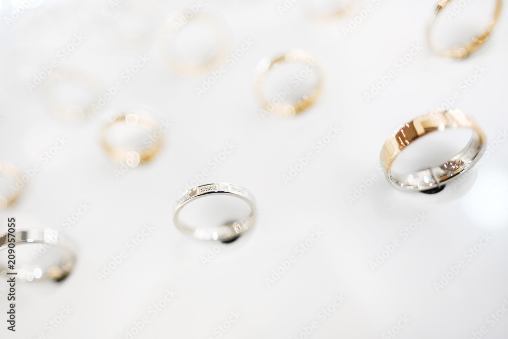 Gold jewelry ring, a lot of the exhibition on the stand in the store on a white background, close-up. Gold jewelry ring, a lot of the exhibition on the stand in the store on a white background, close-up.