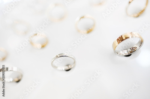 Gold jewelry ring, a lot of the exhibition on the stand in the store on a white background, close-up.