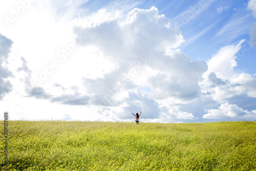 happy girl in a yellow flower field with a dandelion in her hand