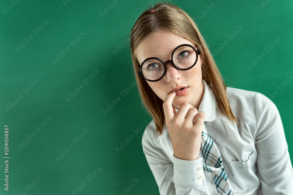 Thoughtful student. Photo of indecisive girl thinking and looking towards. Creative concept with Back to school theme Thoughtful student. Photo of indecisive girl thinking and looking towards. Creative concept with Back to school theme