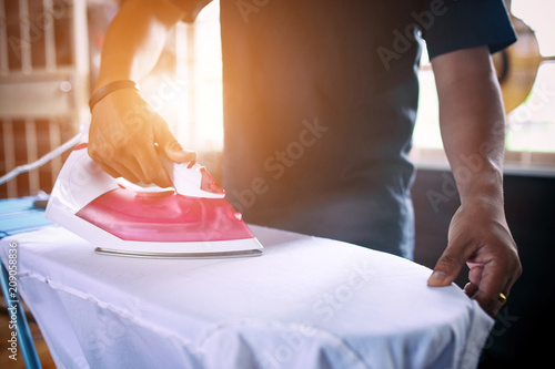 Fotografie, Tablou Men working ironing is man stronger for the wife.