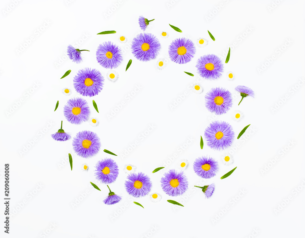 Floral wreath made of violet flowers and chamomile on white background. Flat lay. Top view with copy space.