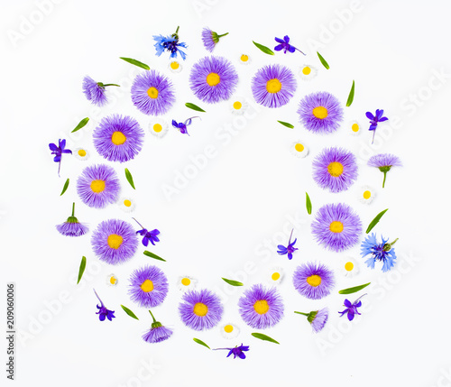 Floral wreath made of violet flowers and chamomile on white background. Flat lay. Top view with copy space.
