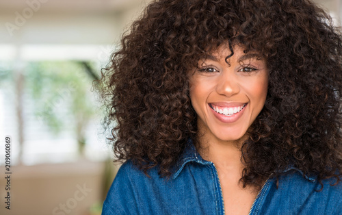 African american woman with a happy face standing and smiling with a confident smile showing teeth