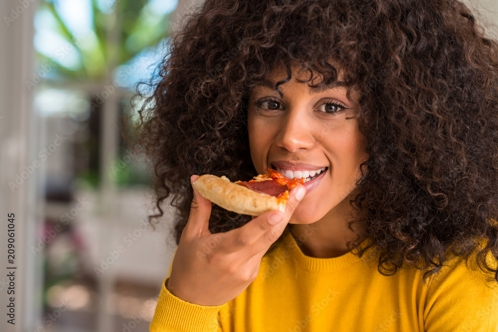 African american woman ready to eat pepperoni pizza slice with a confident expression on smart face thinking serious African american woman ready to eat pepperoni pizza slice with a confident expression on smart face thinking serious