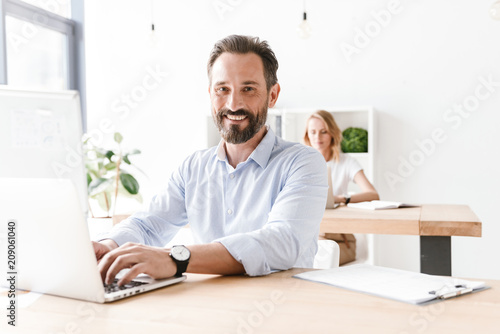 Happy man manager working on laptop computer