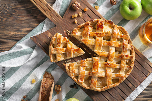 Φωτογραφία Wooden board with tasty apple pie on table
