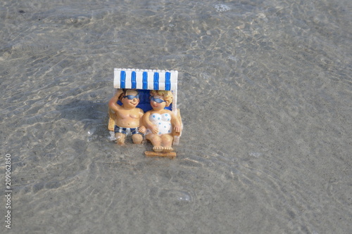 Happy couple makes beach holiday. Ein Urlauberpaar sitzt glücklich lächelnd im Strandkorb. 