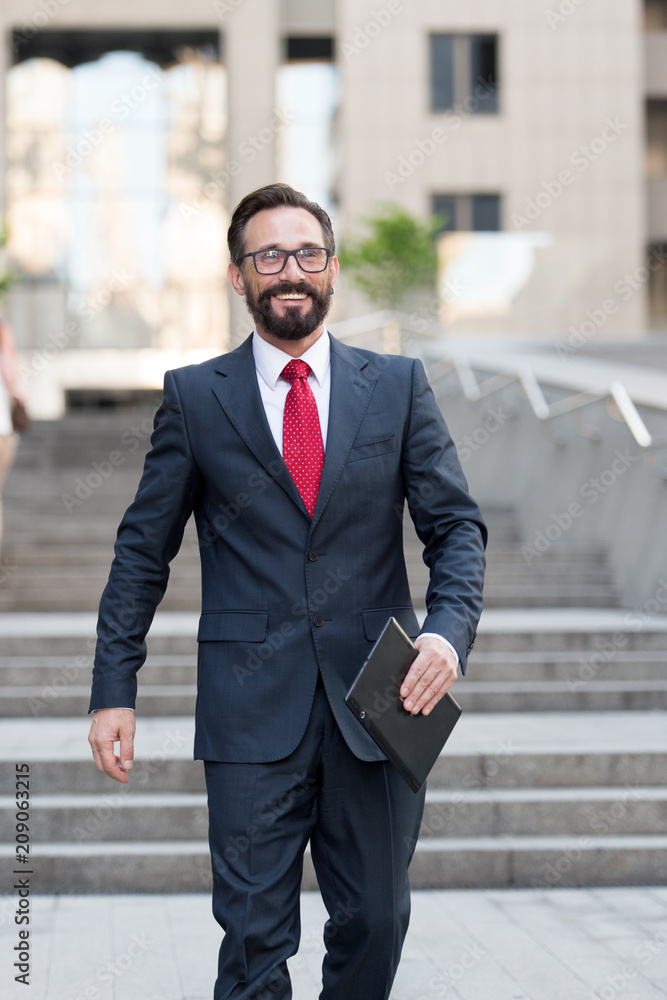 businessman stands at office building with tablet in hand. person dressed in business suit and white shirt do business affairs happy and successfully with tablet businessman stands at office building with tablet in hand. person dressed in business suit and white shirt do business affairs happy and successfully with tablet