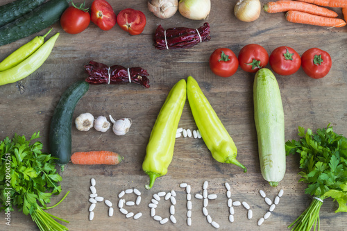 Various fresh vegetables from market on wooden background making sign eat healthy