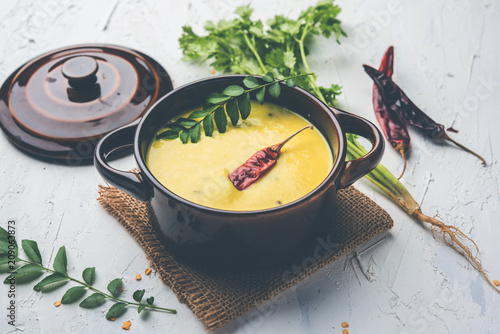 Indian Cuisine Kadhi - Vegetarian Curry Made of Buttermilk And Chick Pea Flour. served in a bowl or Karahi over moody background, selective focus photo