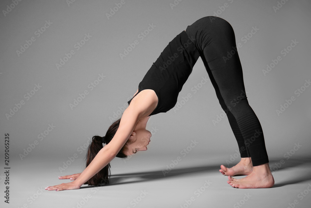 Young woman practicing yoga on grey background Young woman practicing yoga on grey background