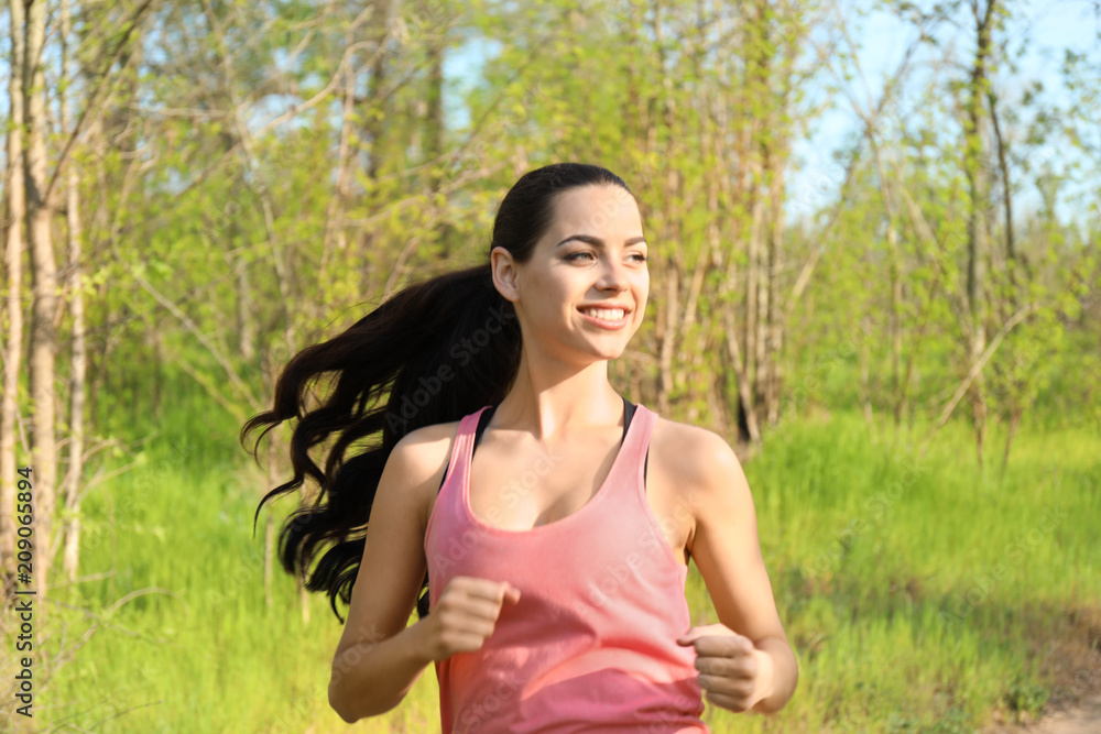 Sporty young woman running in park Sporty young woman running in park