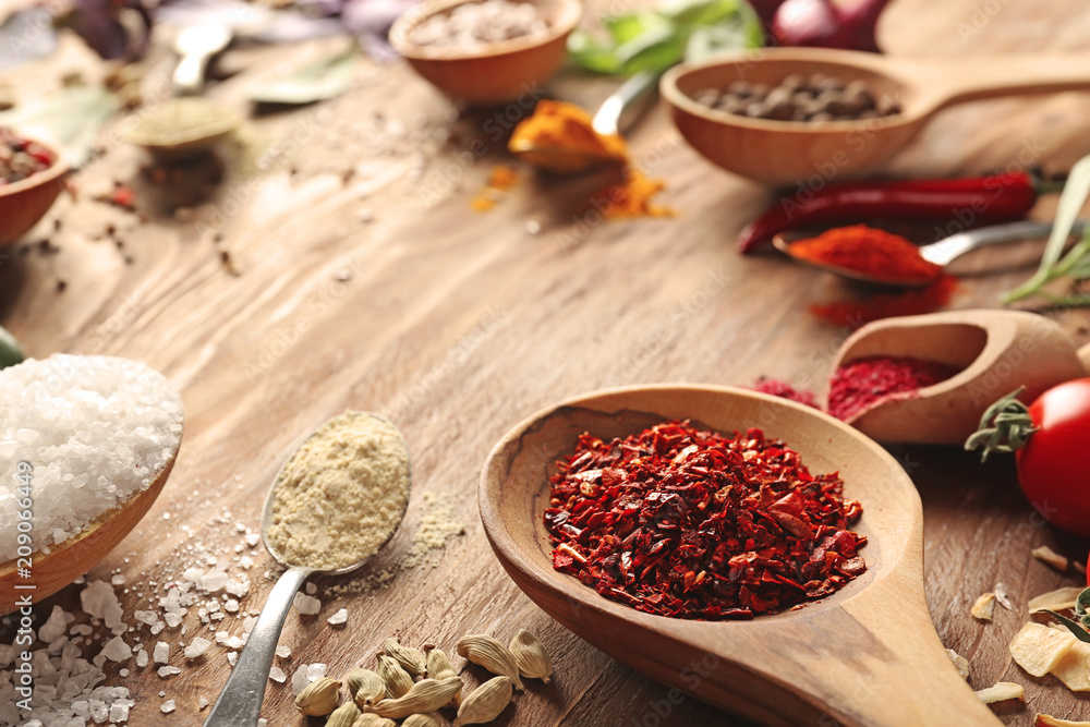 Spoons with different spices on wooden table Spoons with different spices on wooden table