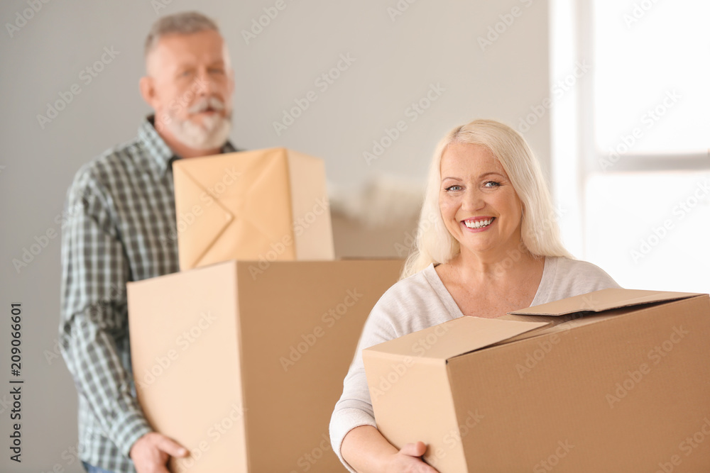 Mature couple with moving boxes at new home Mature couple with moving boxes at new home