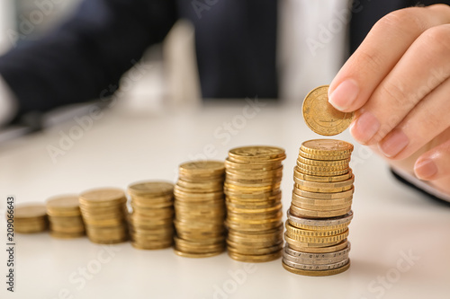 Woman stacking coins on table. Savings concept