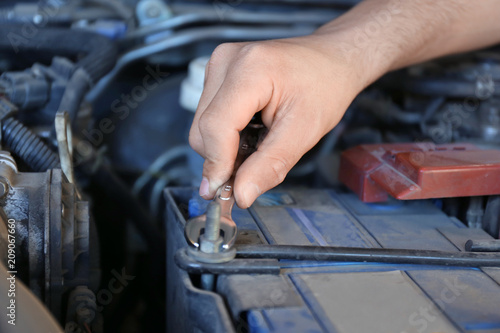Male mechanic fixing car in service center, closeup