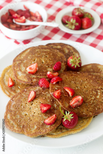 Useful breakfast of pancakes with linseed flour and strawberry-honey sauce.