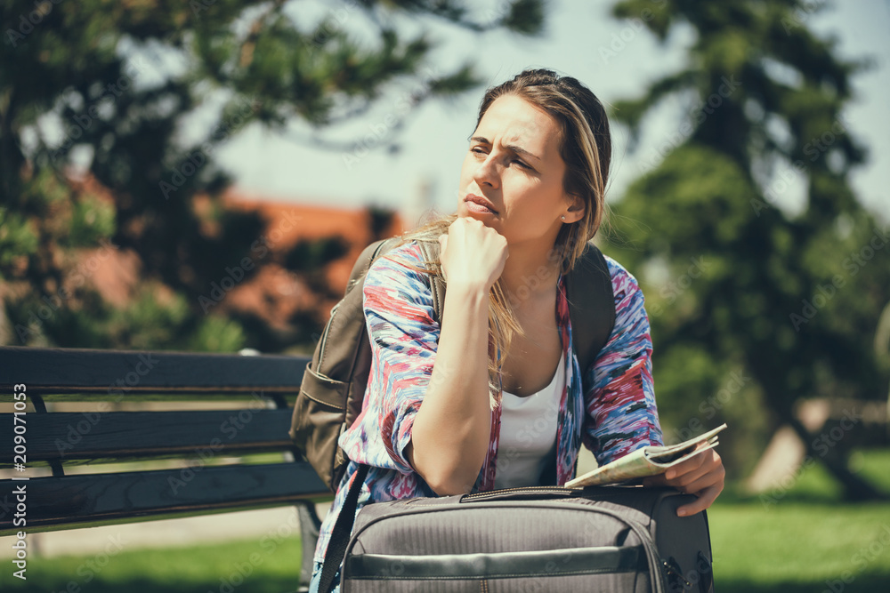 Fototapeta premium Young woman is going on vacation. She is waiting for her transportation.