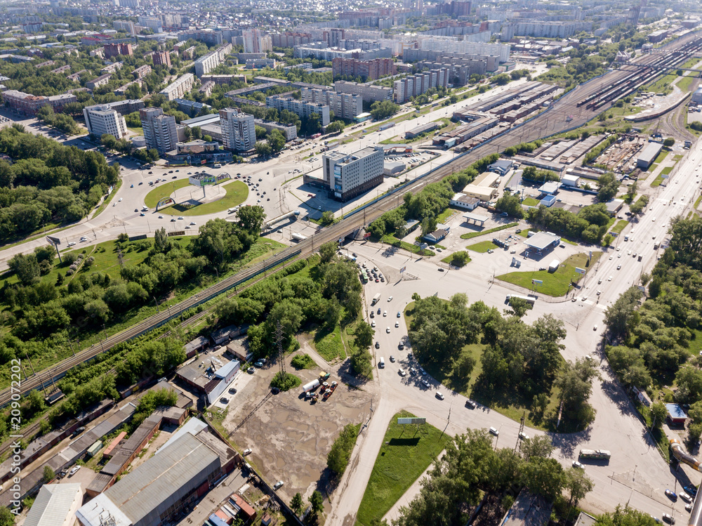 Aerial view of two square in the city with two roundabout traffic, streets and buildings with green trees