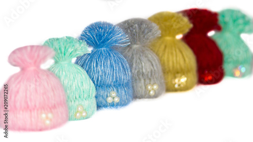 seven beautiful multi-colored caps - handmade brooches lined up waiting for the lucky owners