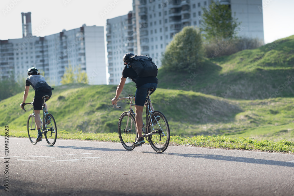 Obraz premium Active male athletes riding bicycles on an open country road