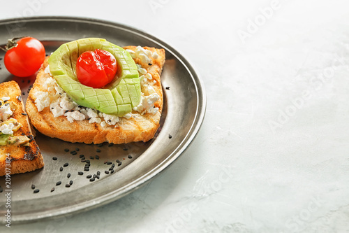 Plate with tasty toast on light background