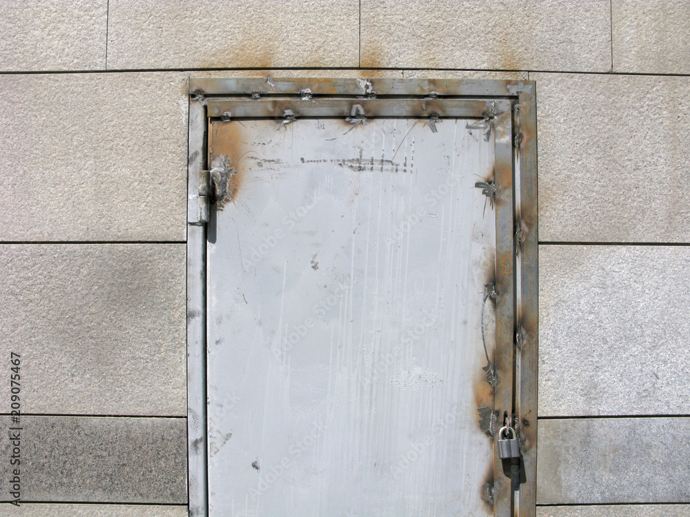 Arc welding on the old metal door. Weld seams on metal door frame and door hinge. Padlock on the door. Arc welding on the old metal door. Weld seams on metal door frame and door hinge. Padlock on the door.