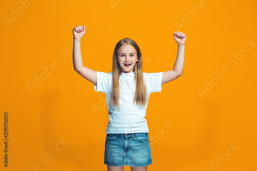 Happy success teen girl celebrating being a winner. Dynamic energetic image of female model