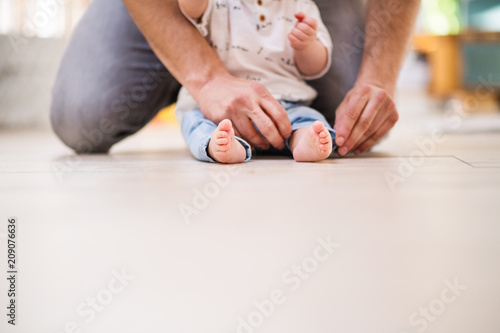 Unrecognizable father with a baby son at home. Copy space.