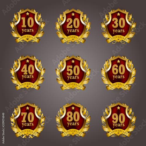 Set of gold anniversary badges with laurel wreaths, shield, numbers. Decorative emblem of jubilee on gray background. Filigree element, frame, border, icon, logo for web, page design in vintage style